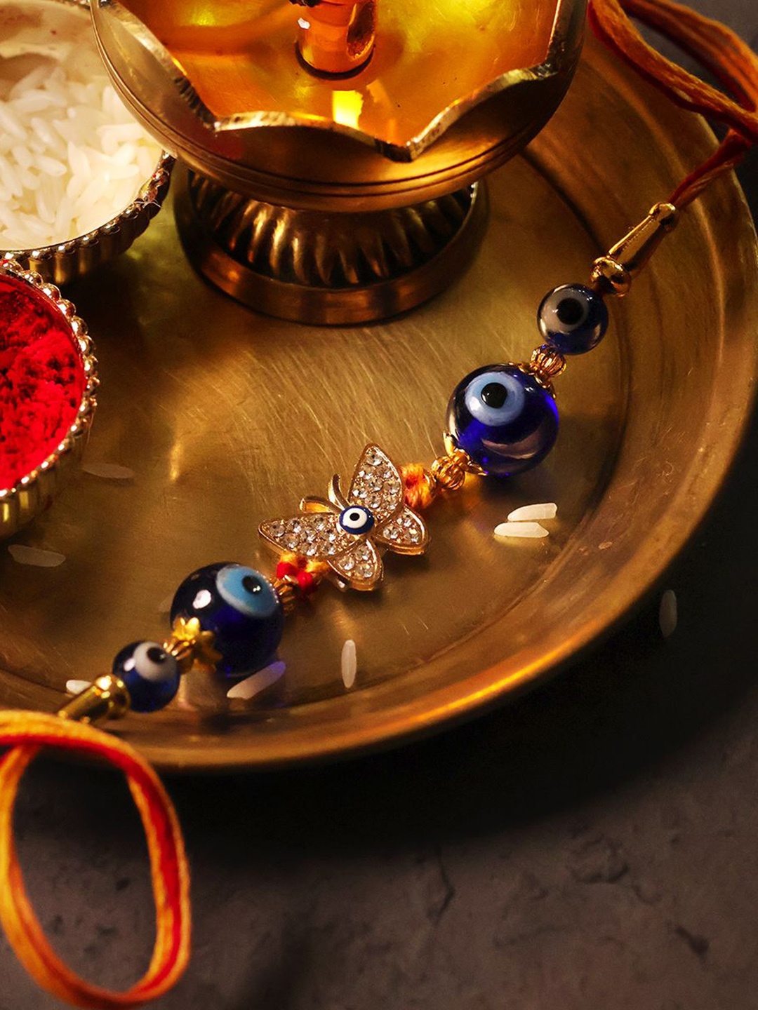

Shubhanjali Set Of 2 Evil Eye Diamond Butterfly Rakhis With Roli Chawal & Greeting Card, Blue