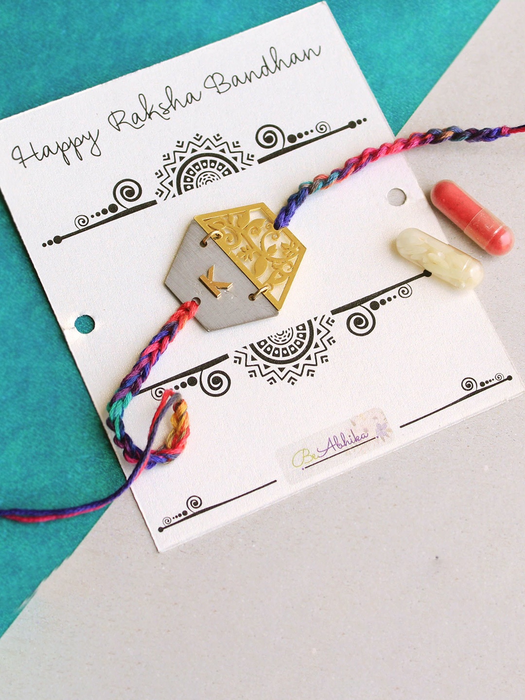 

BeAbhika Blooming M Initial Beaded Thread Rakhi With Roli Chawal Capsules, White