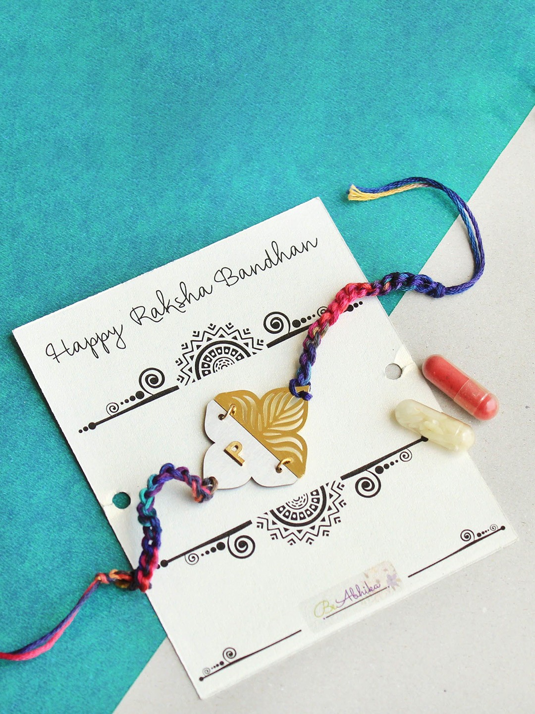 

BeAbhika "G" Intial Personalised Floral Plate Thread Rakhi with Roli Chawal Capsules, Gold
