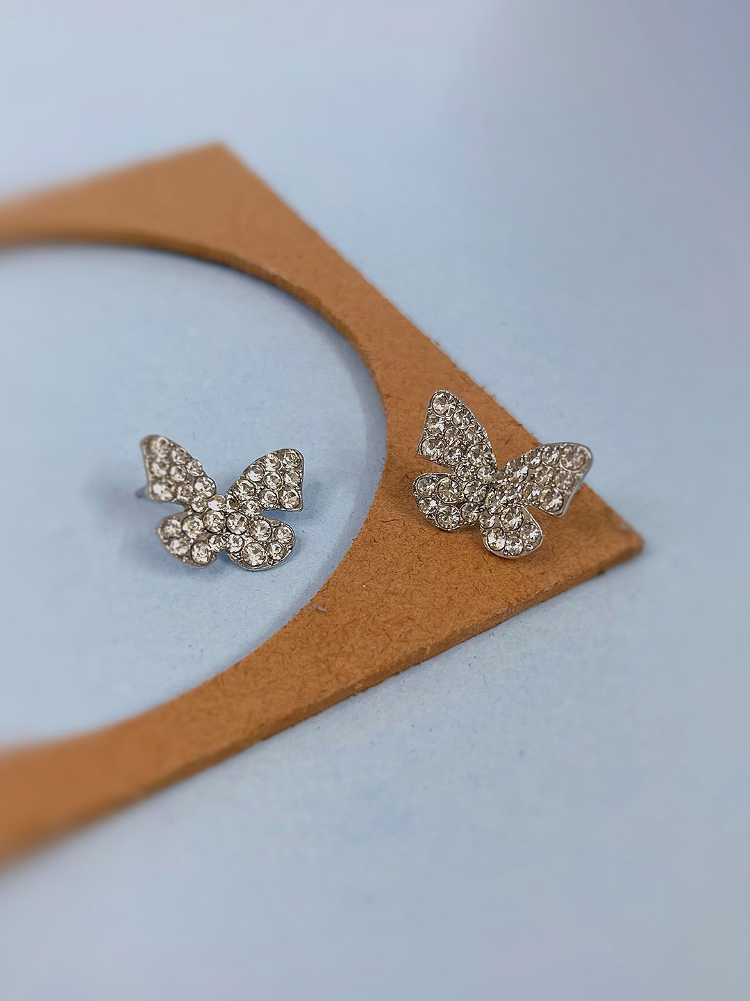 

SUBHAGALANKAR Brass Plated Rhinestone Studded Butterfly Shaped Studs Earrings, Silver