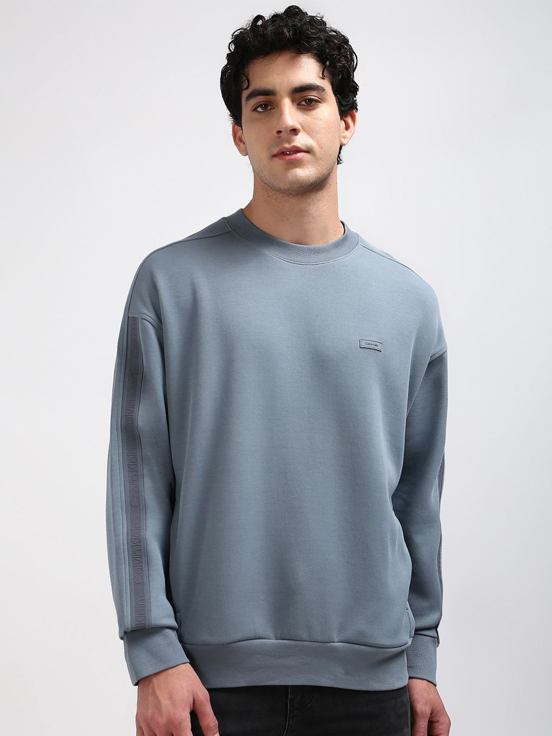 

Calvin Klein Jeans Men Solid Brand Logo Round Neck Sweatshirt, Blue