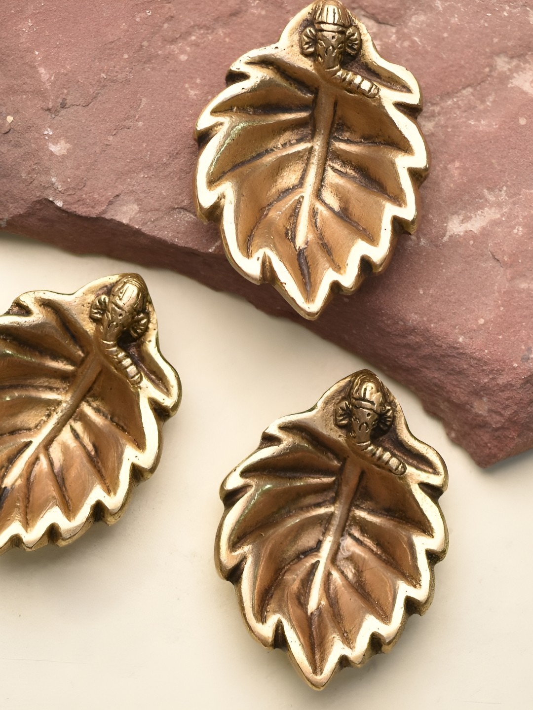 

Indianshelf 3 Pieces Gold Toned Textured Ganpati & Leaf Diyas Pooja Essentials