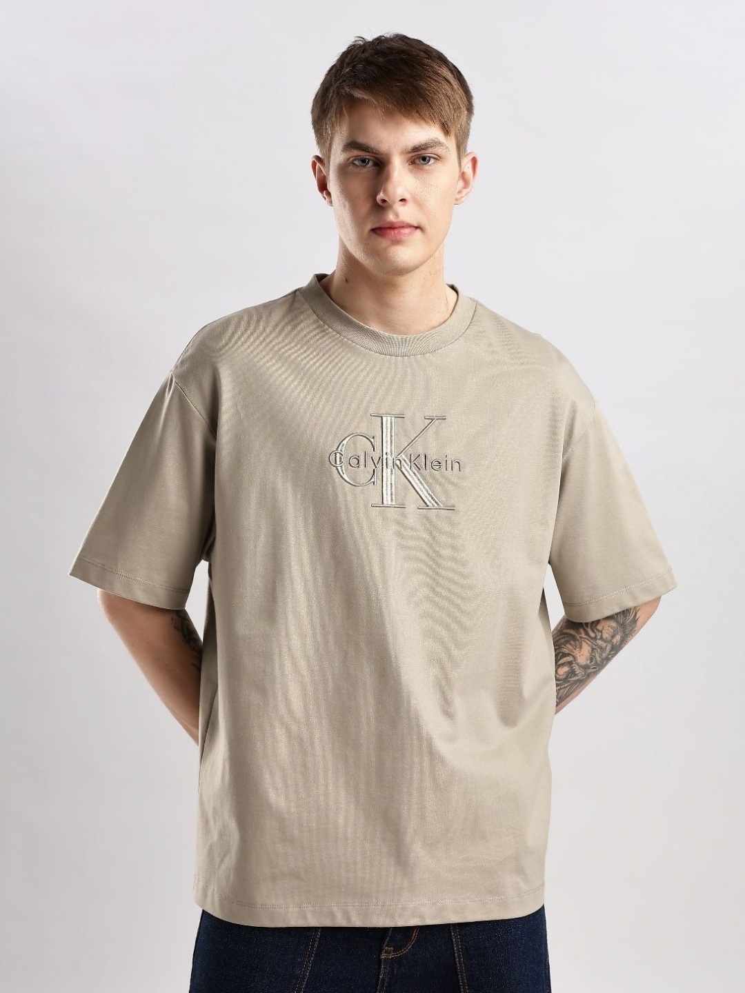 

Calvin Klein Jeans Men Brand Logo Printed Drop-Shoulder Sleeves Pockets T-shirt, Beige