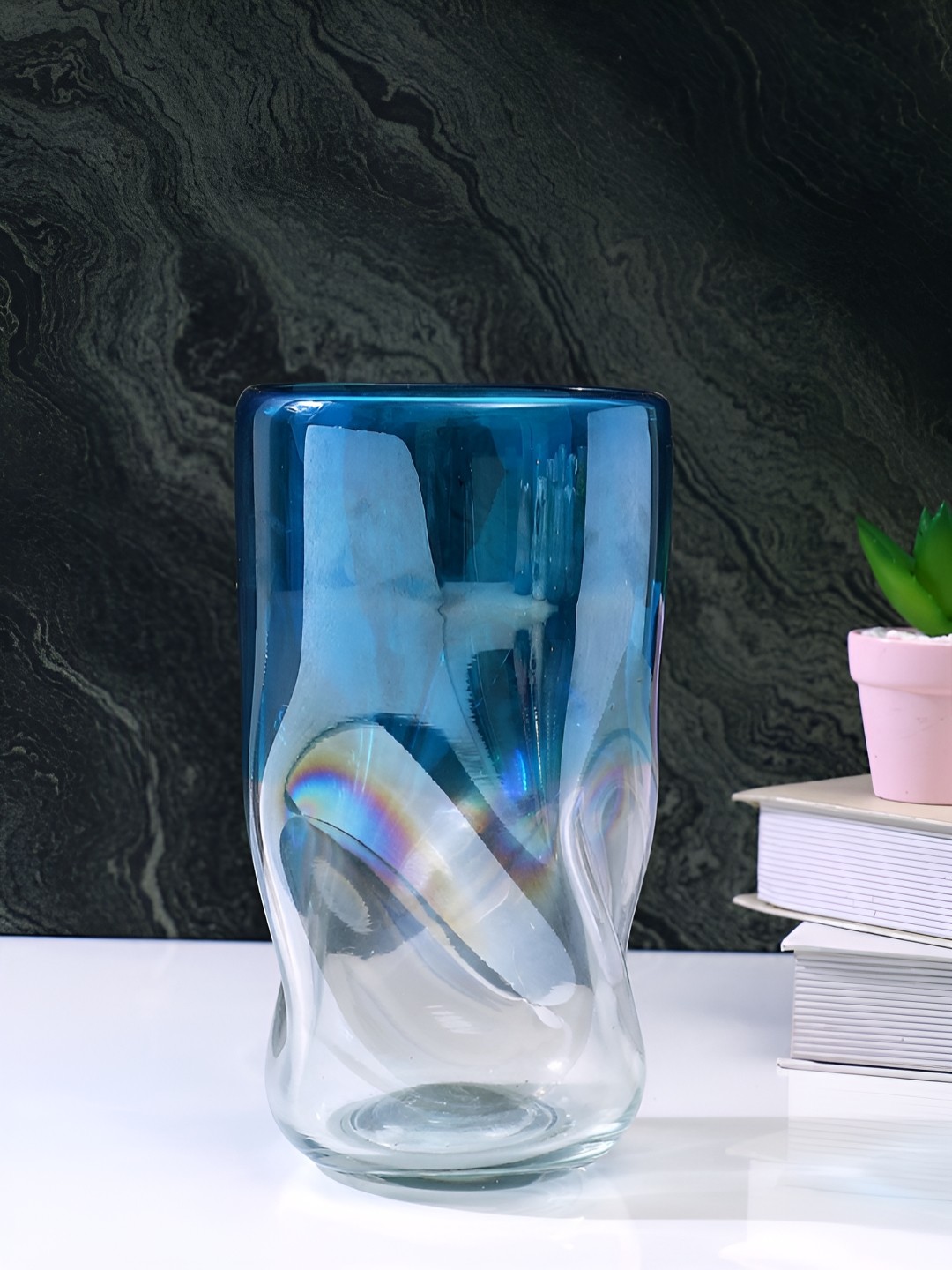 

Myntra Elegant Homes Wave Blue & Transparent Textured Glass Flower Vase