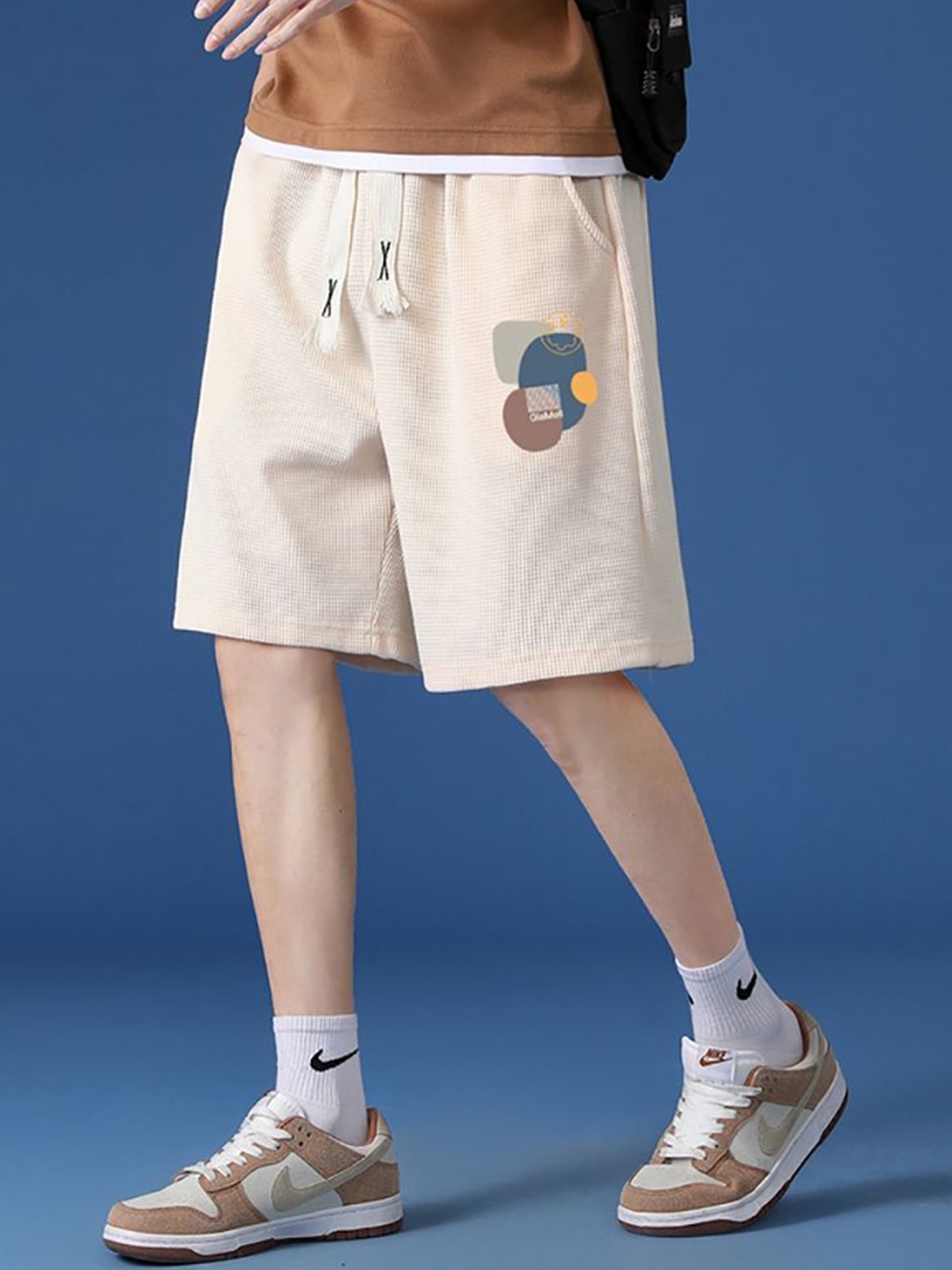 

StyleCast x Revolte Men Graphic Printed Mid-Rise Regular Shorts, Beige