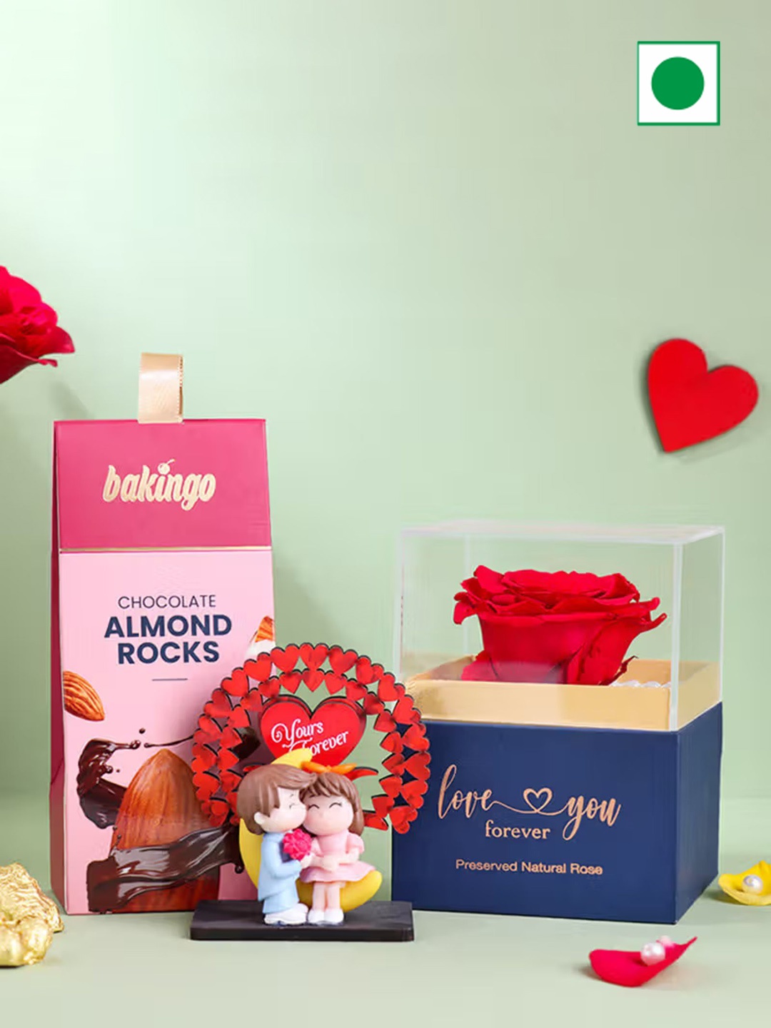 

Floweraura Hamper of Natural Preserved Red Rose & Almond Rocks & Couple Showpiece 500g