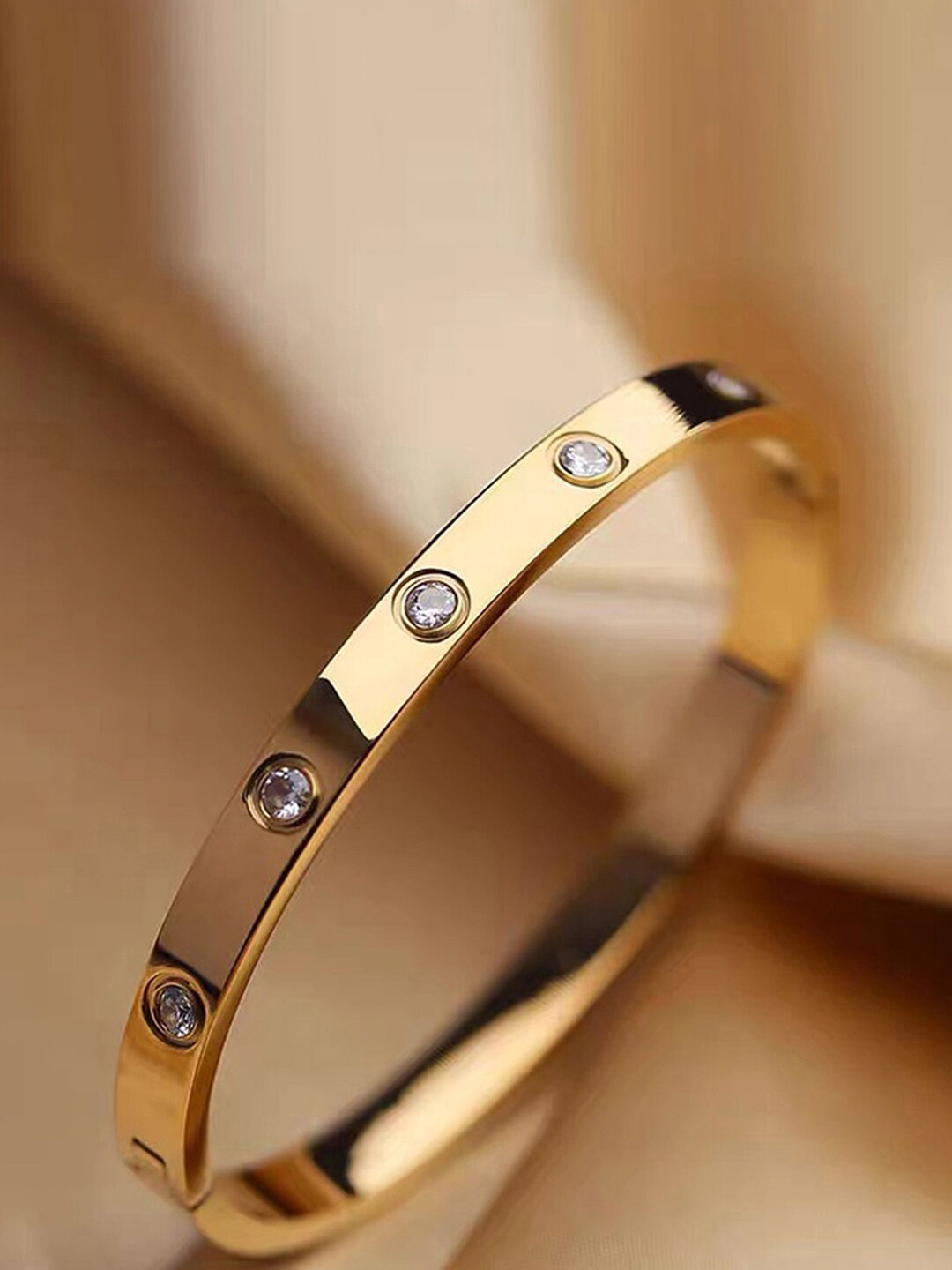 

Designs By Jewels Galaxy Women Gold-Toned American Diamond Gold-Plated Bangle-Style Bracelet