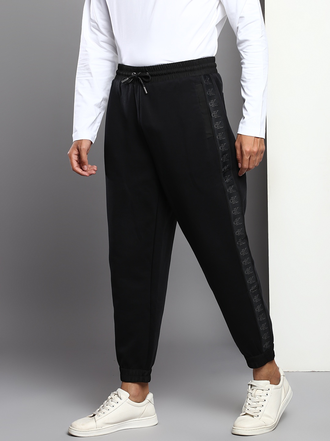 

Calvin Klein Jeans Men Black Solid Mid-Rise Regular Joggers With Logo Printed Side Panels