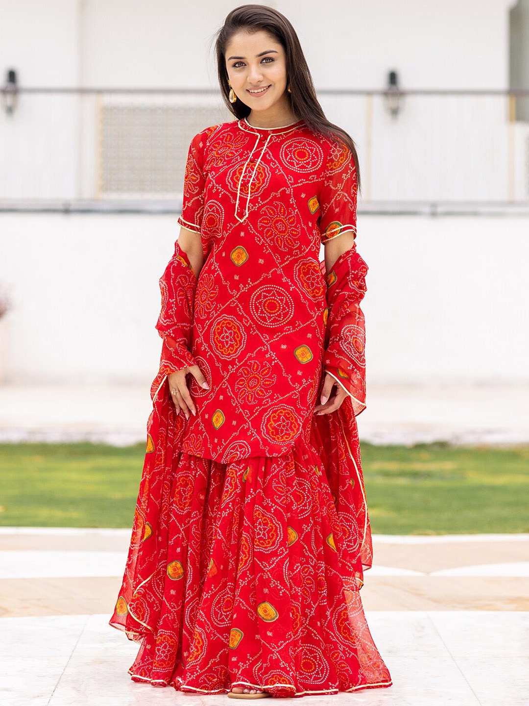 

Ambraee Women Red Bandhani Printed Silk Chiffon Kurta with Sharara & Dupatta