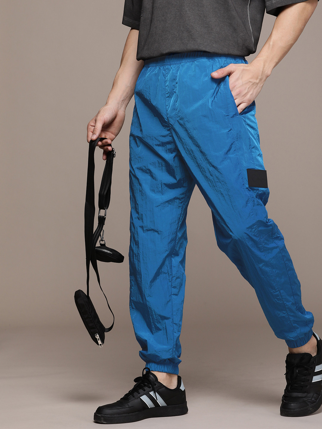 

Calvin Klein Jeans Men Solid Regular Fit Mid-Rise Joggers With Brand Logo Applique Detail, Blue