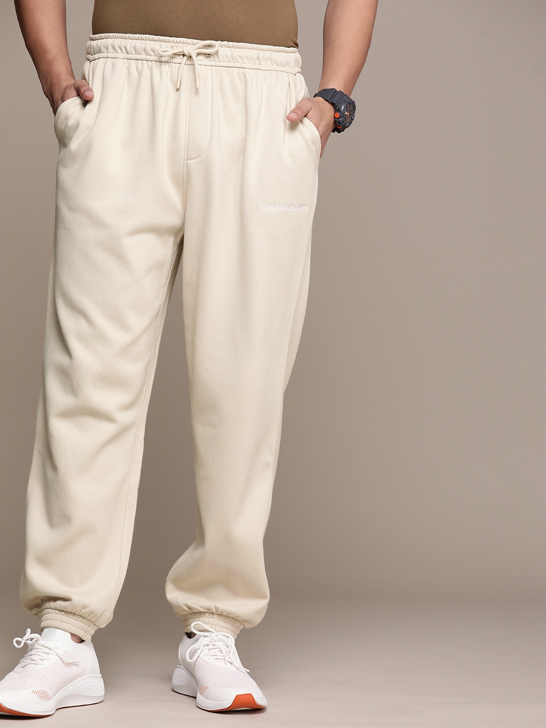 

Calvin Klein Jeans Men Brand Logo Embroidered Mid-Rise Joggers, Beige