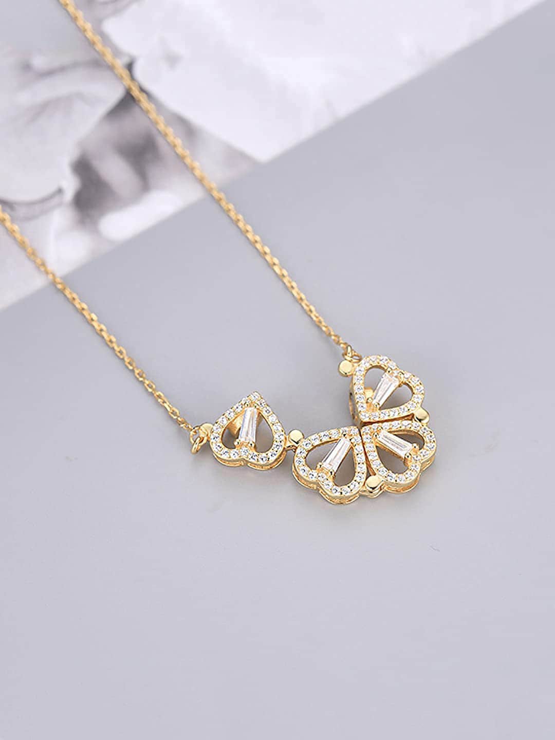 

Jewels Galaxy Gold-Plated Stone Studded Four Hearts Shaped Magnet Pendant With Chain