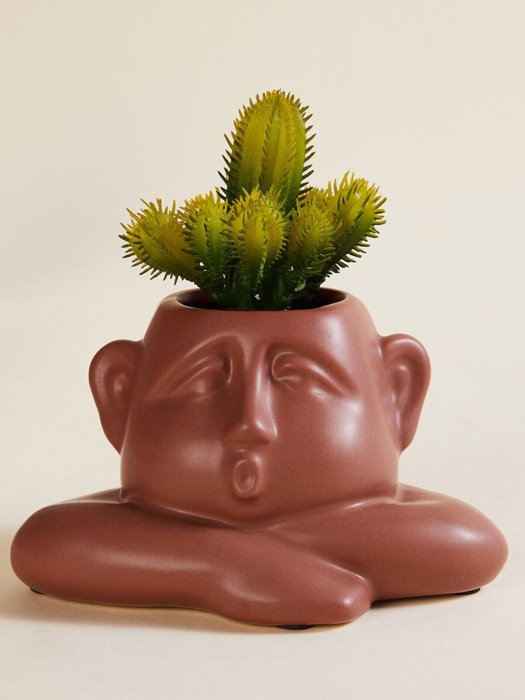 

Home Centre Brown Face Shaped Ceramic Face Shaped Planter Artificial Plant