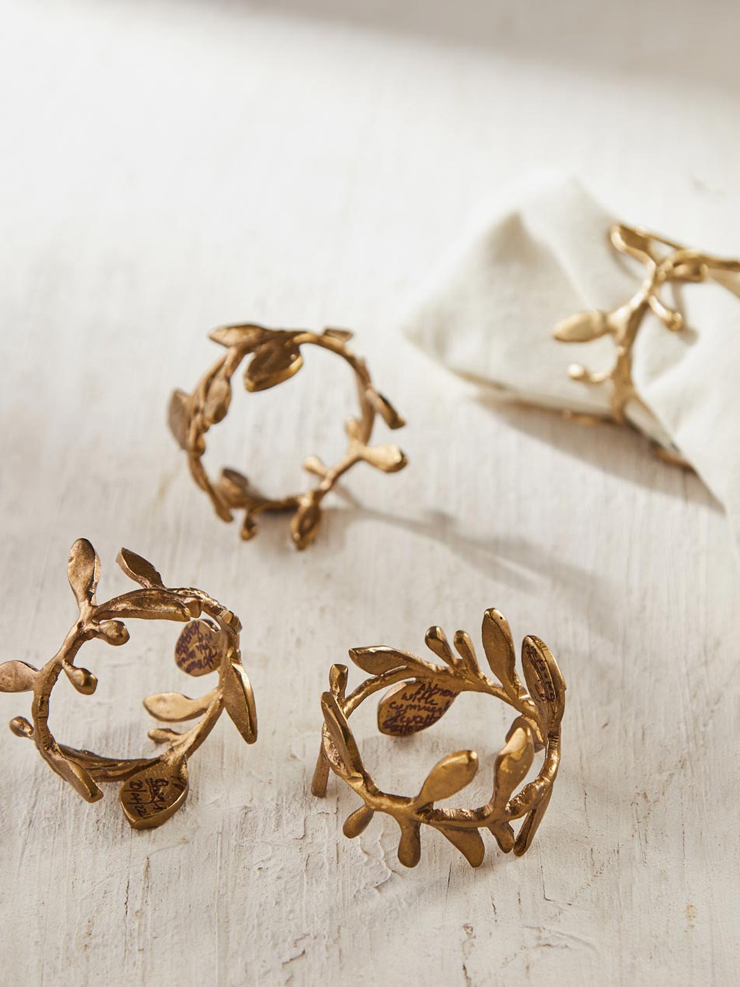 

Fabindia 4 Pcs Dhaani Leaf Metal Napkin Rings, Gold