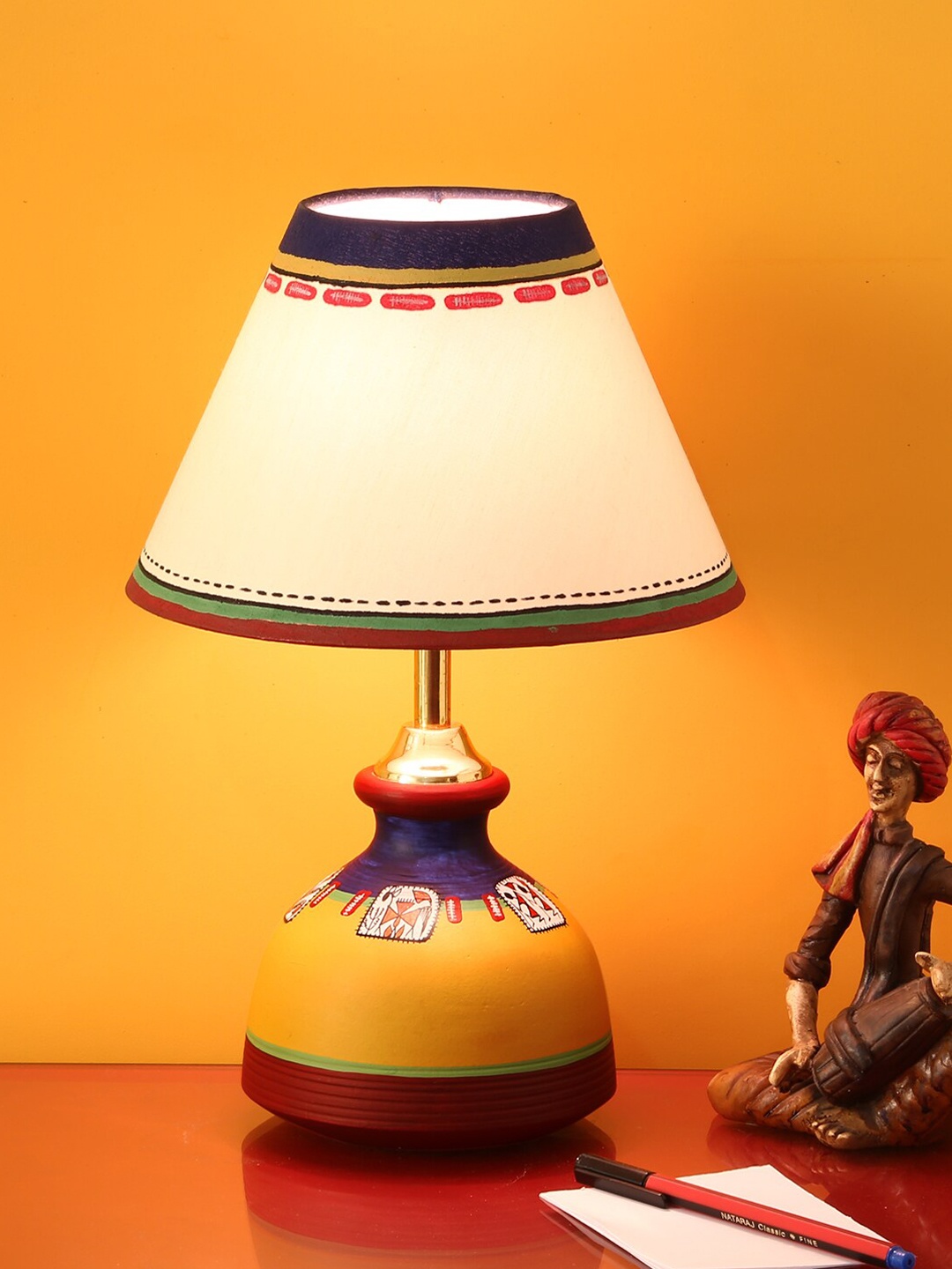 

ExclusiveLane Warli In Light Off White & Yellow Painted Matki Shaped Terracotta Table Lamp