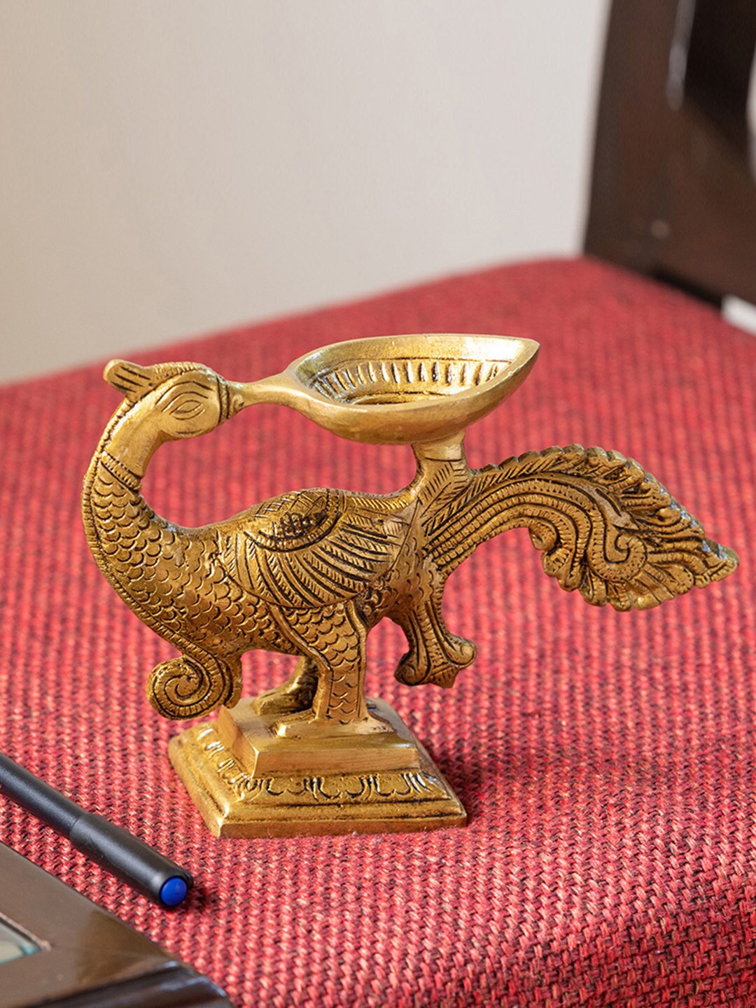 

ExclusiveLane Gleaming Gold-Toned Hand-Etched Peacock Carved Diya