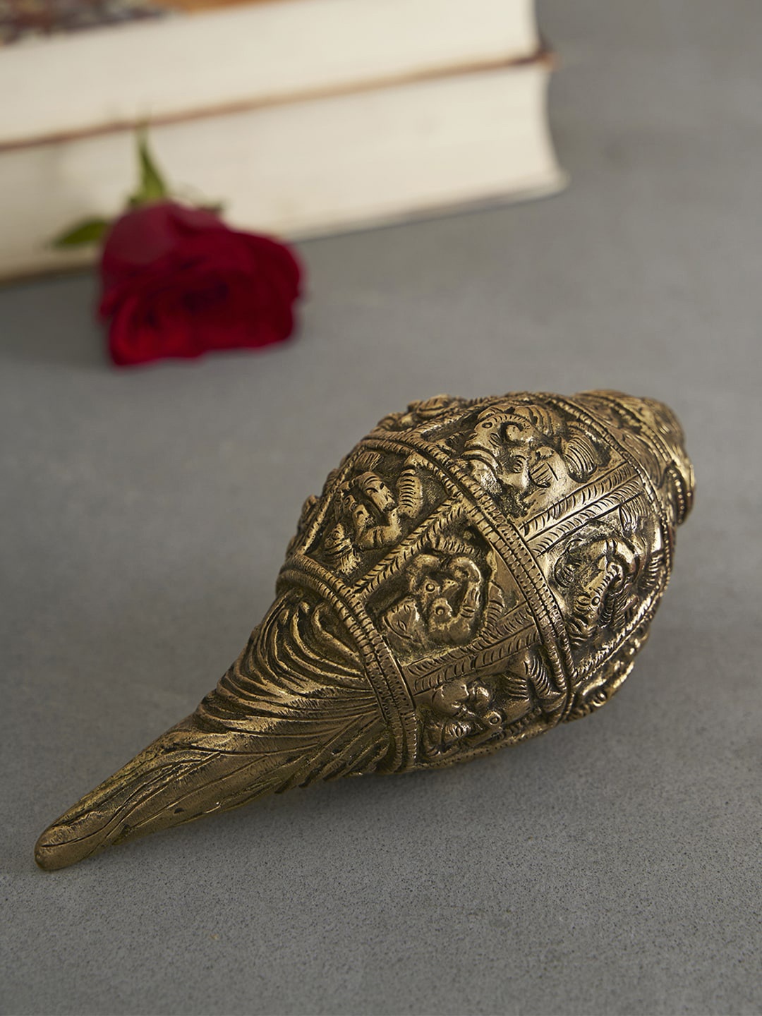 

DecorTwist Gold-Toned Textured Shankh With Ganesh Carving Figurine Showpieces