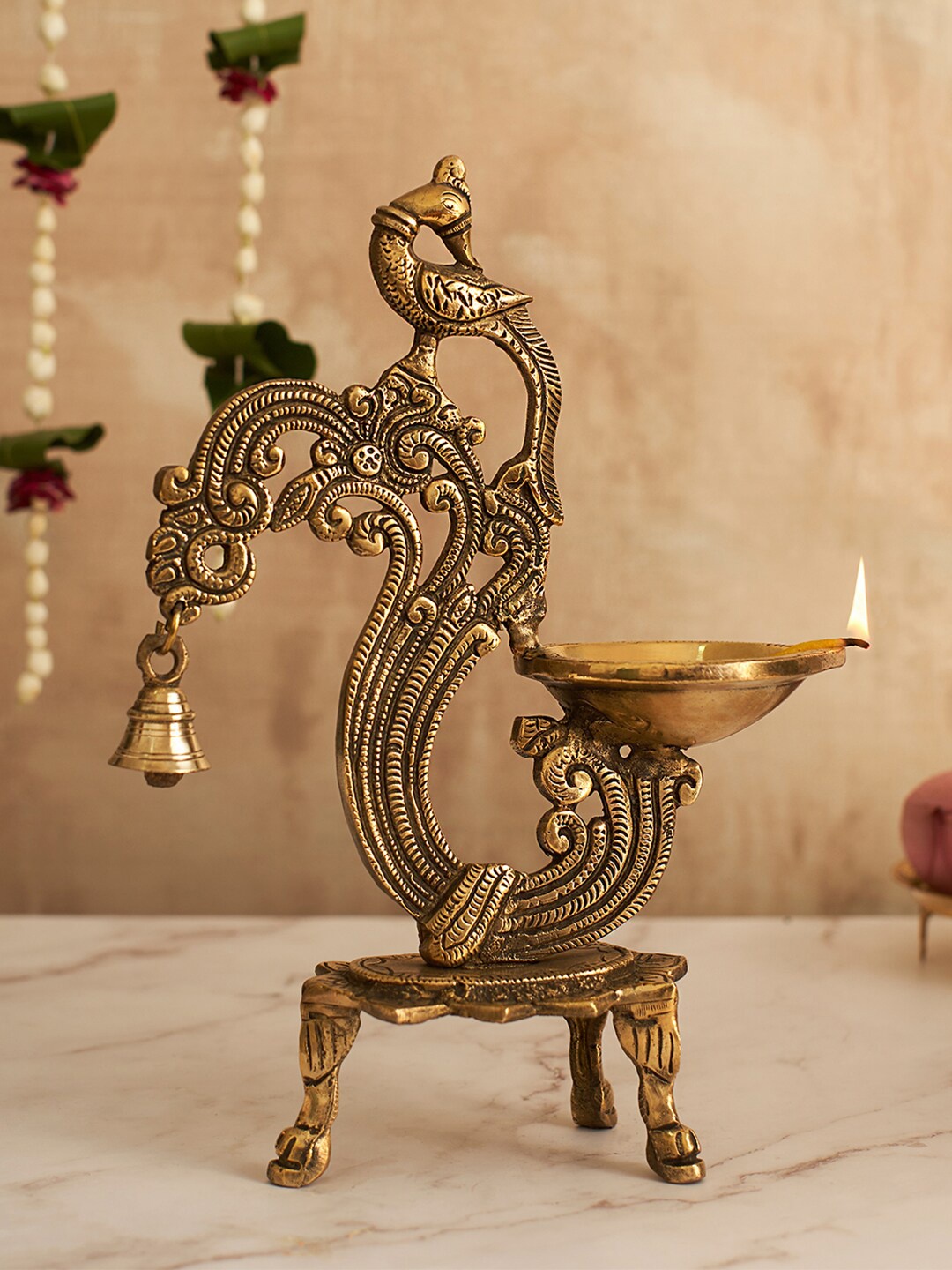 

DecorTwist Gold Toned Brass Peacock Diya With Bell