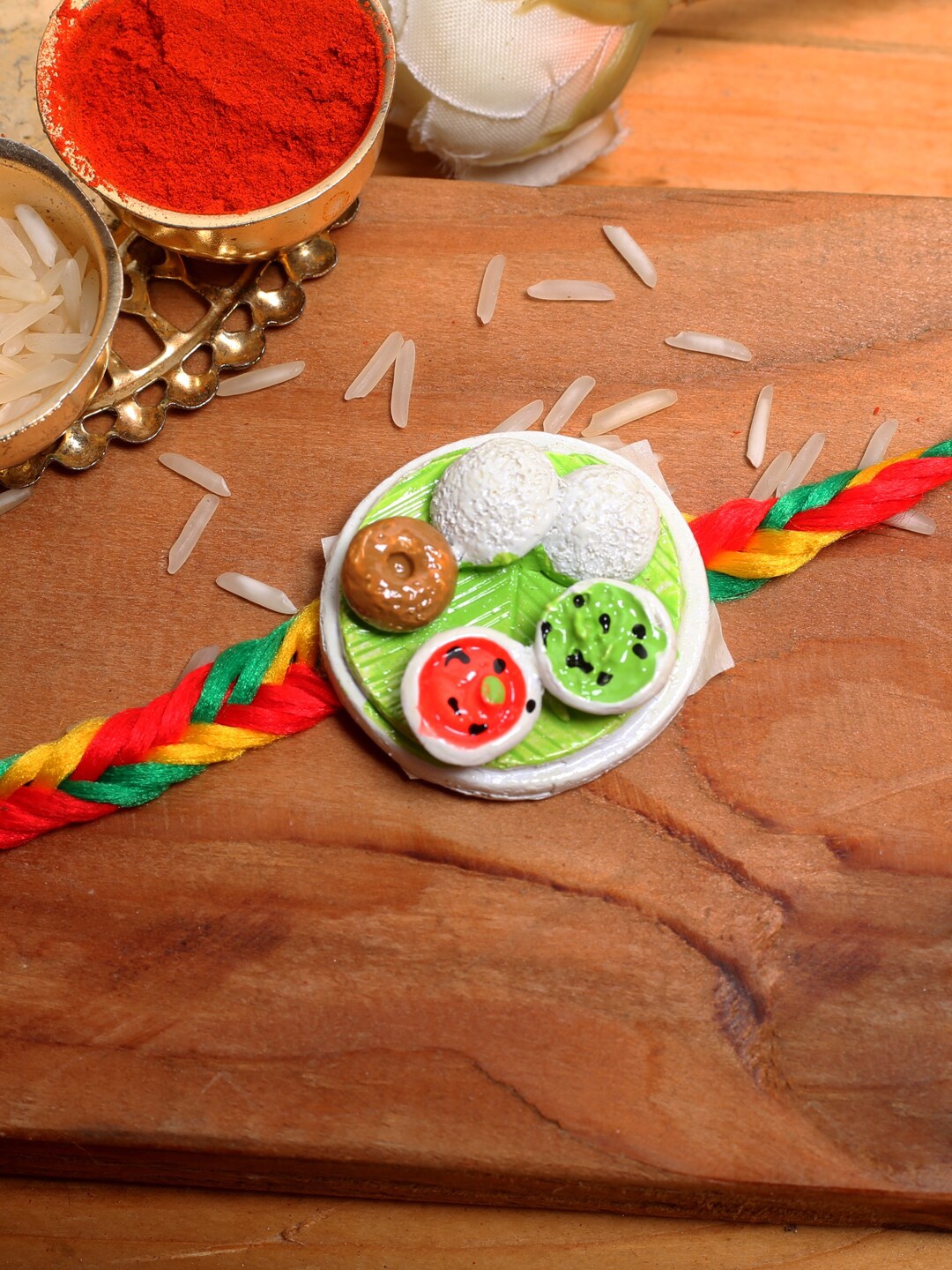 

Aapno Rajasthan Kids South Indian Platter Thread Rakhi With Roli Chawal, Red