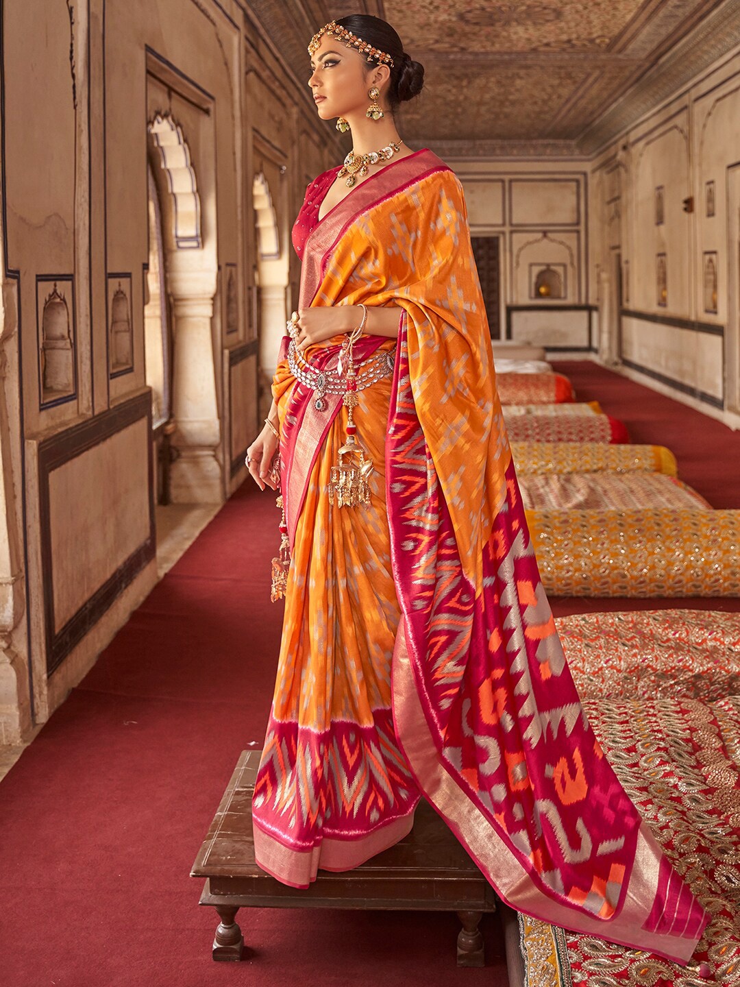 

Anouk Mustard & Red Ethnic Motifs Printed Zari Ikat Saree