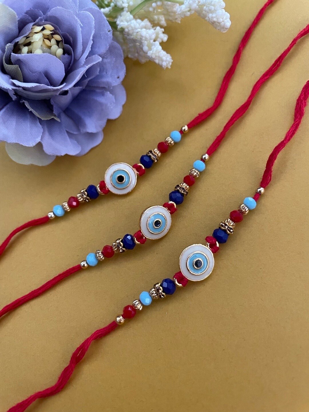 

Digital Dress Room Set Of 3 Evil Eye-Shaped & Beaded Thread Rakhis, Red