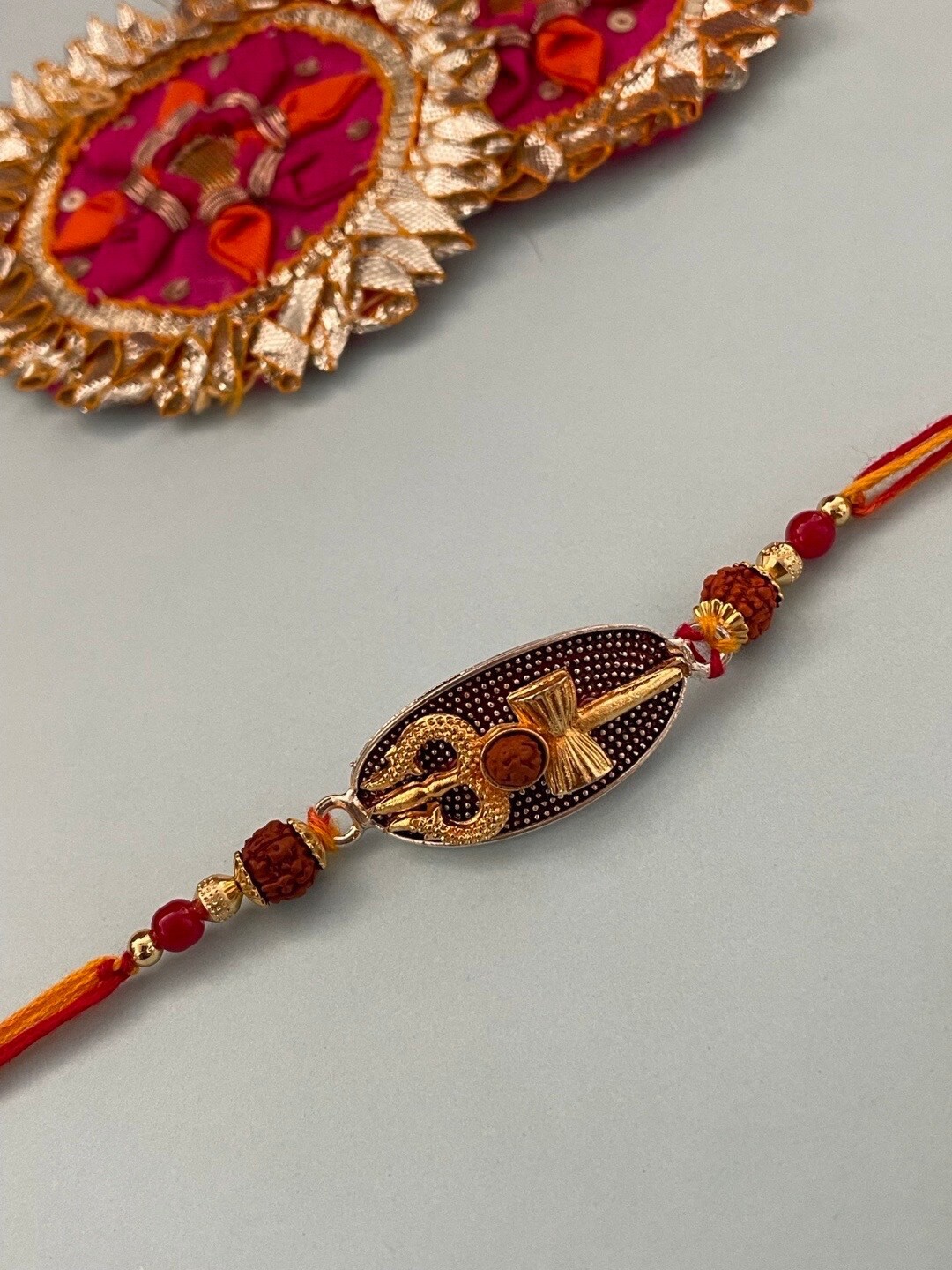 

Digital Dress Room Trishul With Rudraksh & Beaded Charm Thread Rakhi, Gold