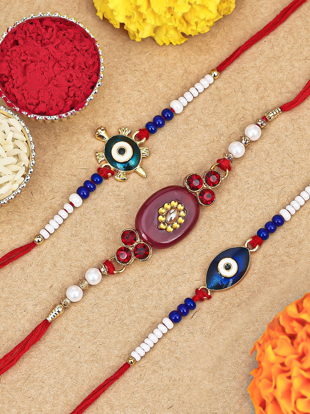 

Sukkhi Rakhi Set Of 3 Gold-Plated Stone-Studded Rakhi With Roli, Rice &GreetingCard