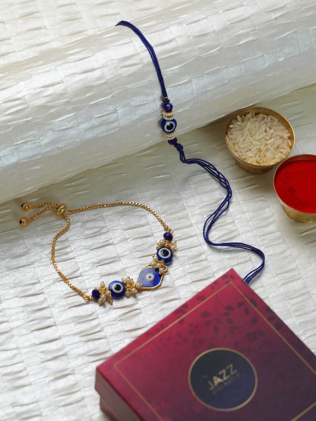 

Jazz and Sizzle Set Of 2 Evil Eye & Beaded Charm Thread Rakhis With Roli & Rice, Blue