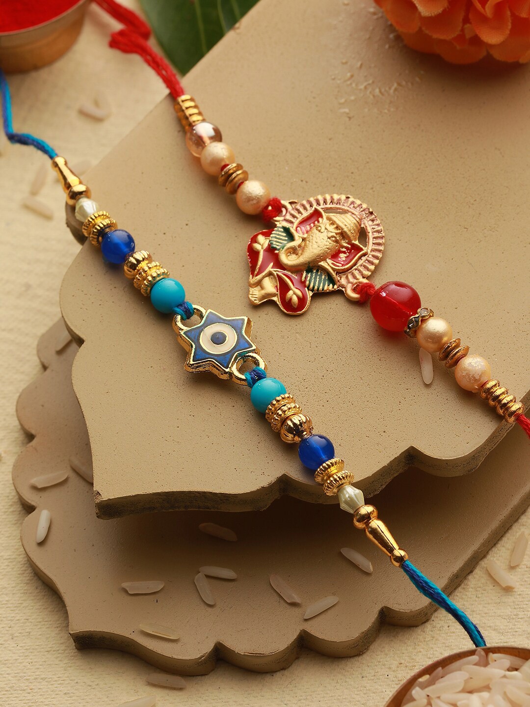 

Saraf RS Jewellery Set Of 2 Evil Eye & Ganesha Rakhi With Roli Chawal, Red