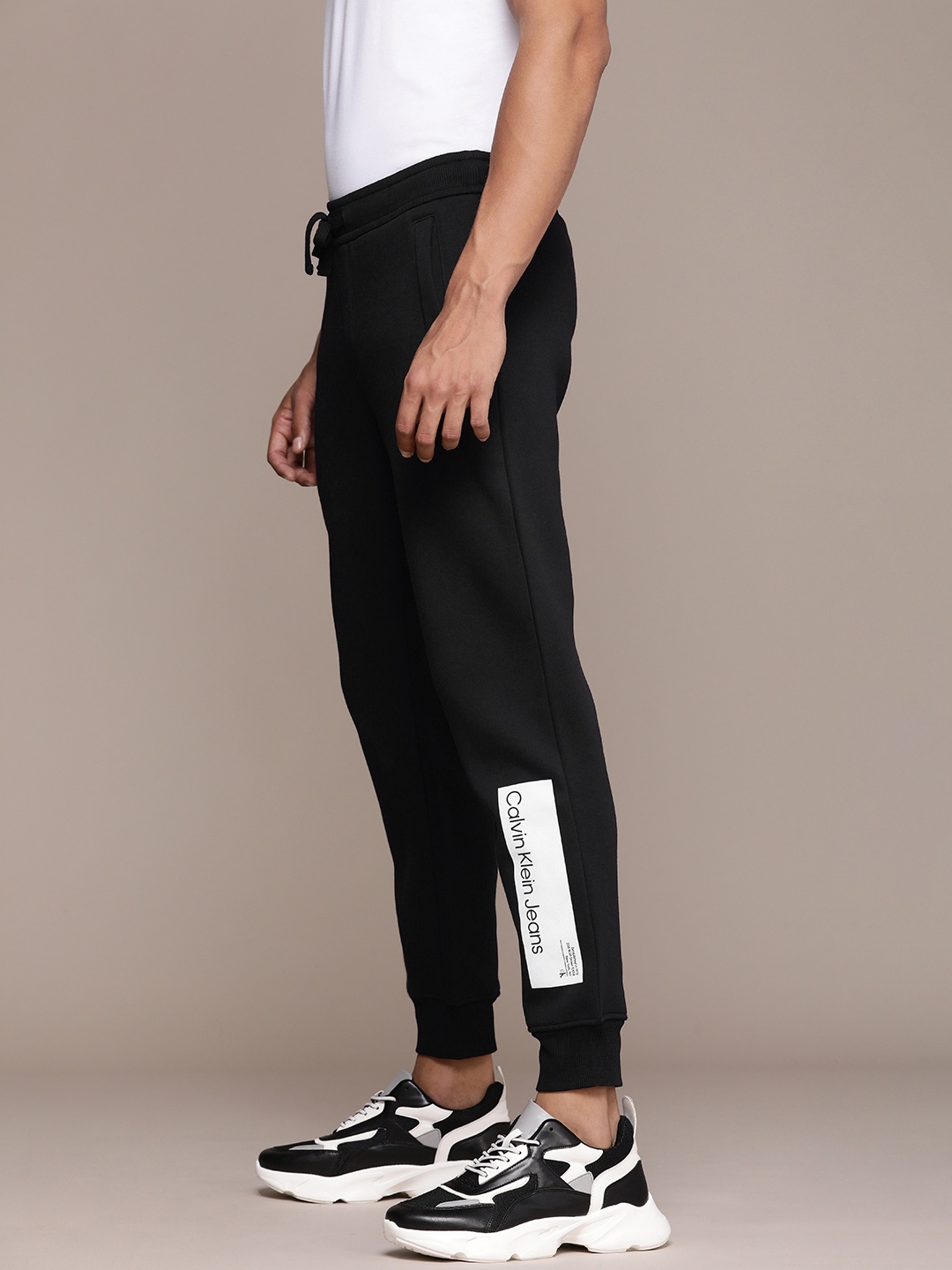 

Calvin Klein Jeans Men Mid-Rise Brand Logo Printed Joggers Track Pants, Black