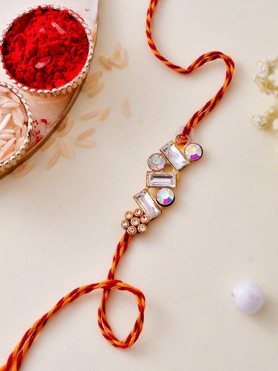 

Aapno Rajasthan Unisex Gold Plated Celestial Diamond Stone Crafted Dazzling Rakhi