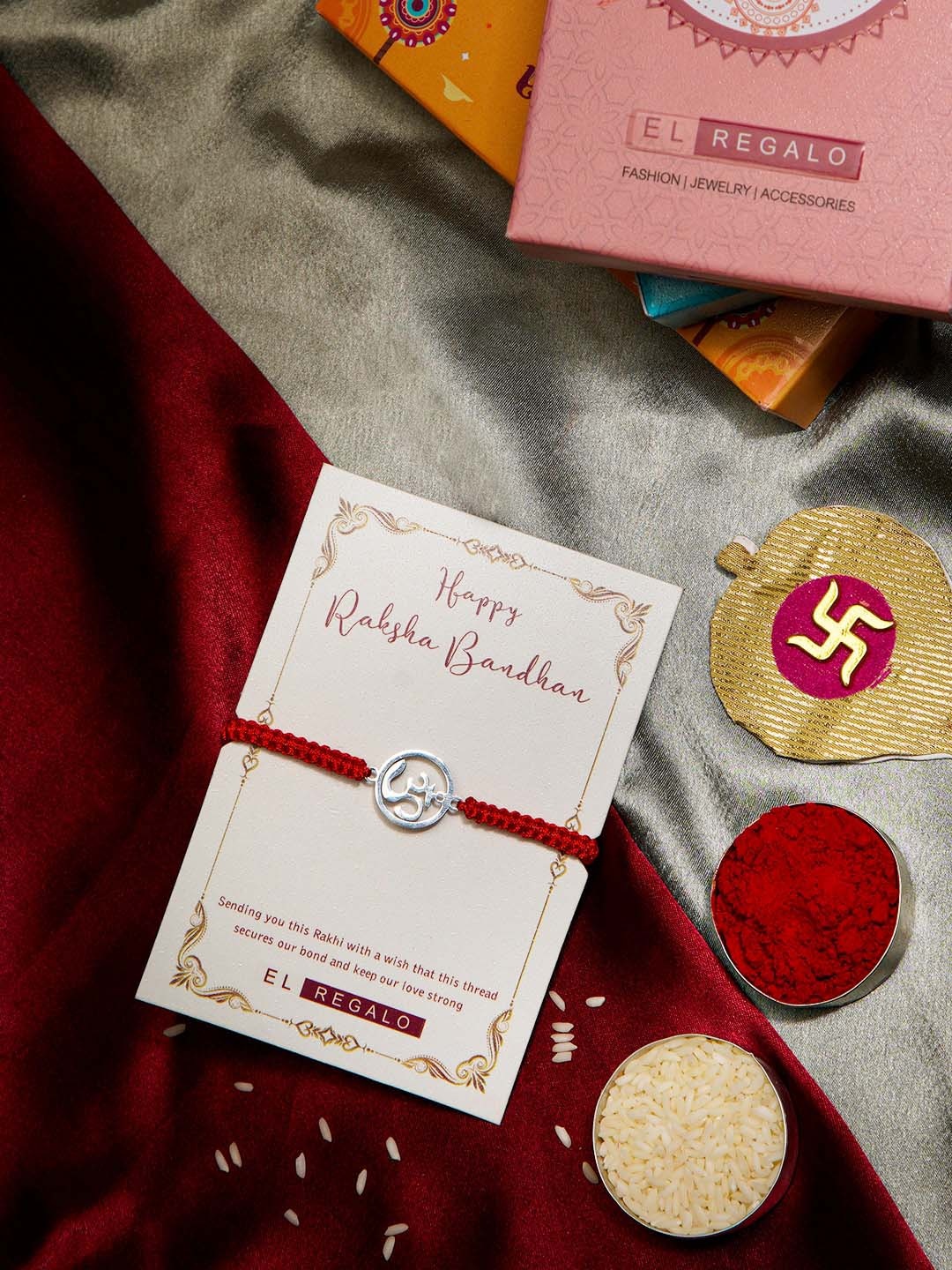 

EL REGALO OM Charm Studded Stainless Steel Rust Free Rakhi With Roli Rice Greeting Card, Red