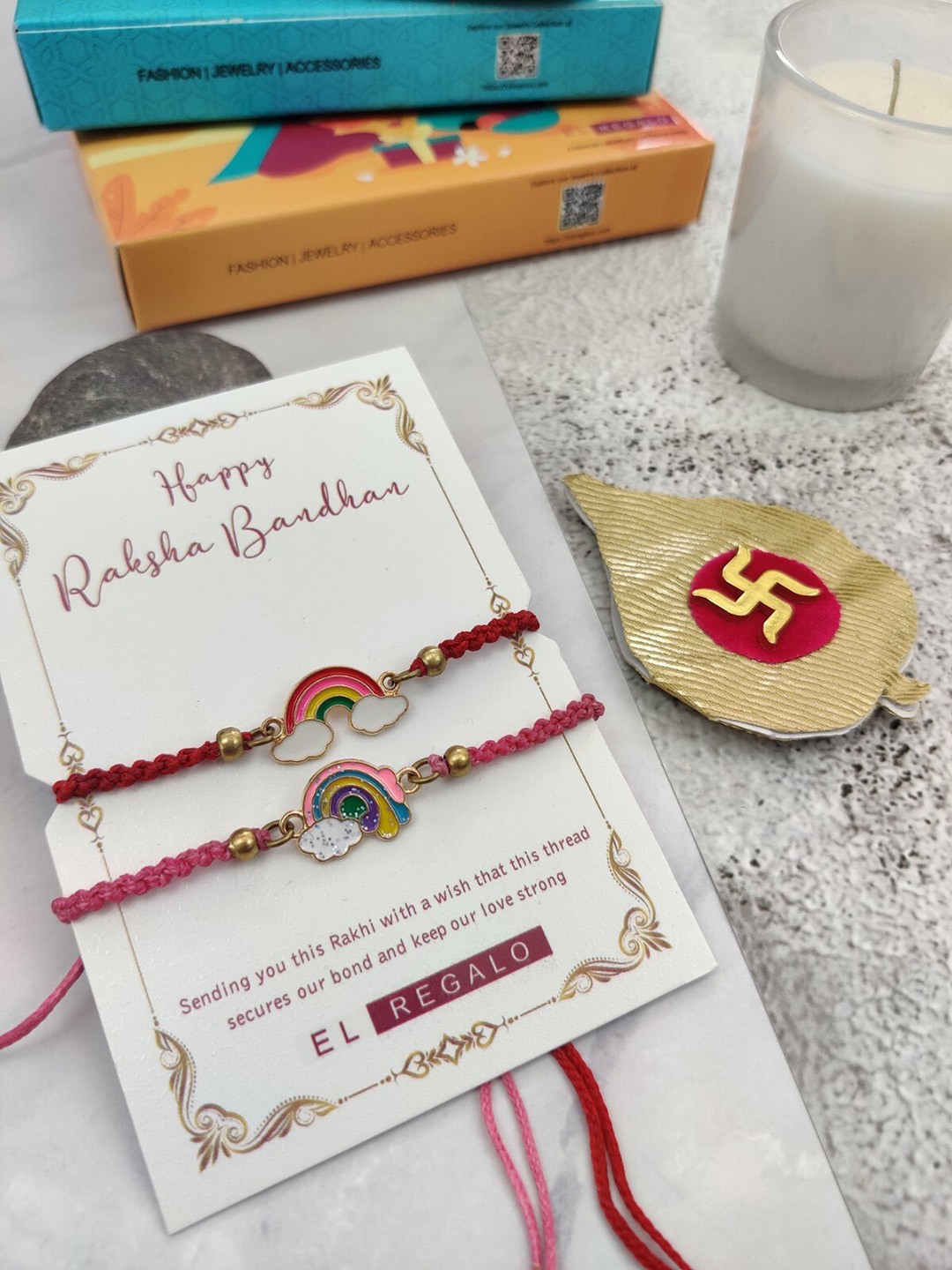 

EL REGALO Kids Boys Set Of 2 Rainbow Charm Rakhi With Candle Greeting Card, Red