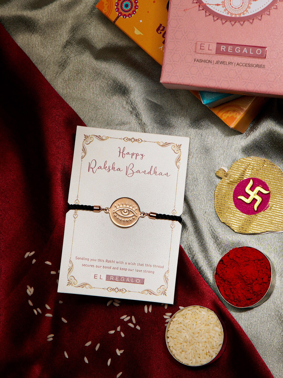 

EL REGALO Evil Eye Charm Stainless Steel Rust Free Rakhi With Roli Chawal & Greeting Card, Rose gold