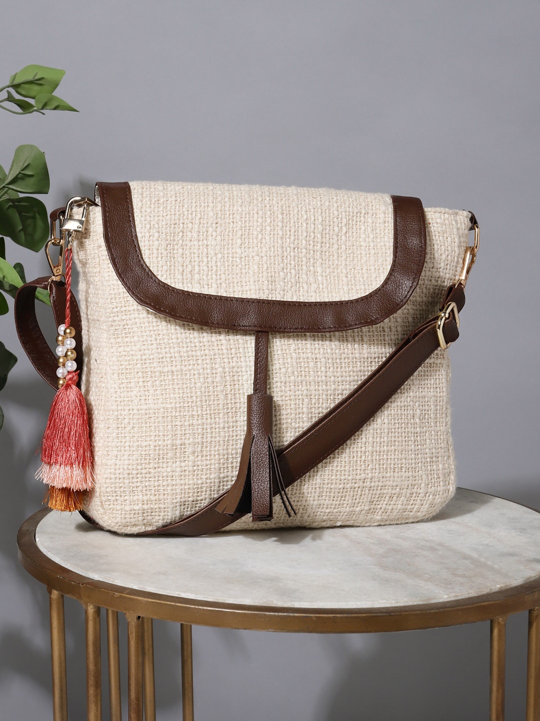 

DEEBACO Self Design Structured Cotton Sling Bag With Tasselled, Cream