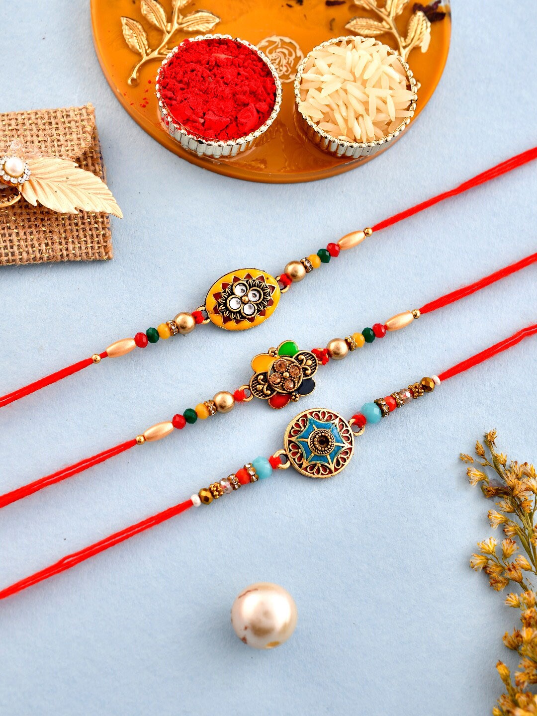 

Aapno Rajasthan Unisex Set Of 3 Beaded Rakhis With Roli Rice & Greeting card, Red