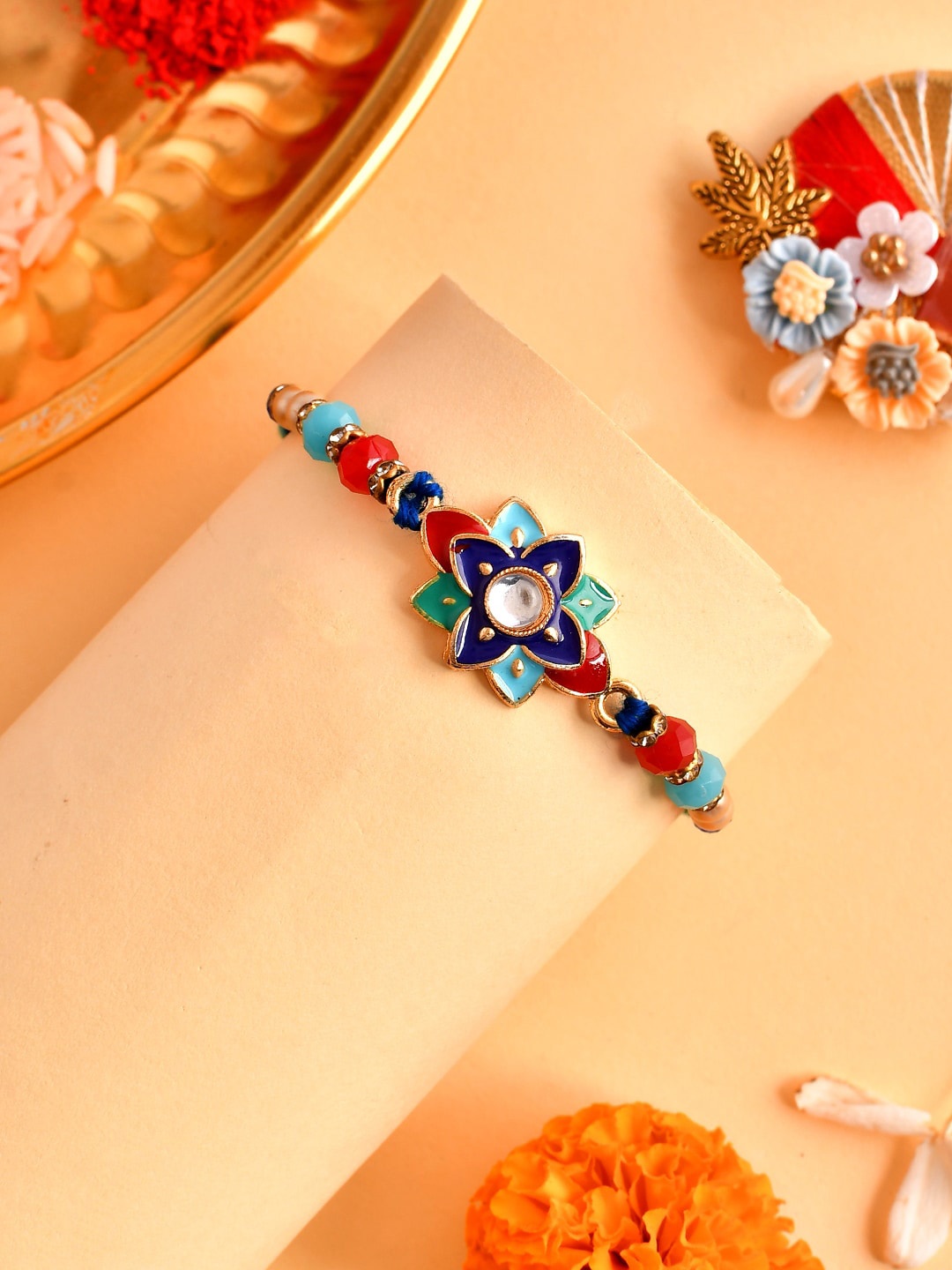 

Aapno Rajasthan Unisex Beaded Enamelled Rakhi With Roli Chawal & Greeting Card, Blue