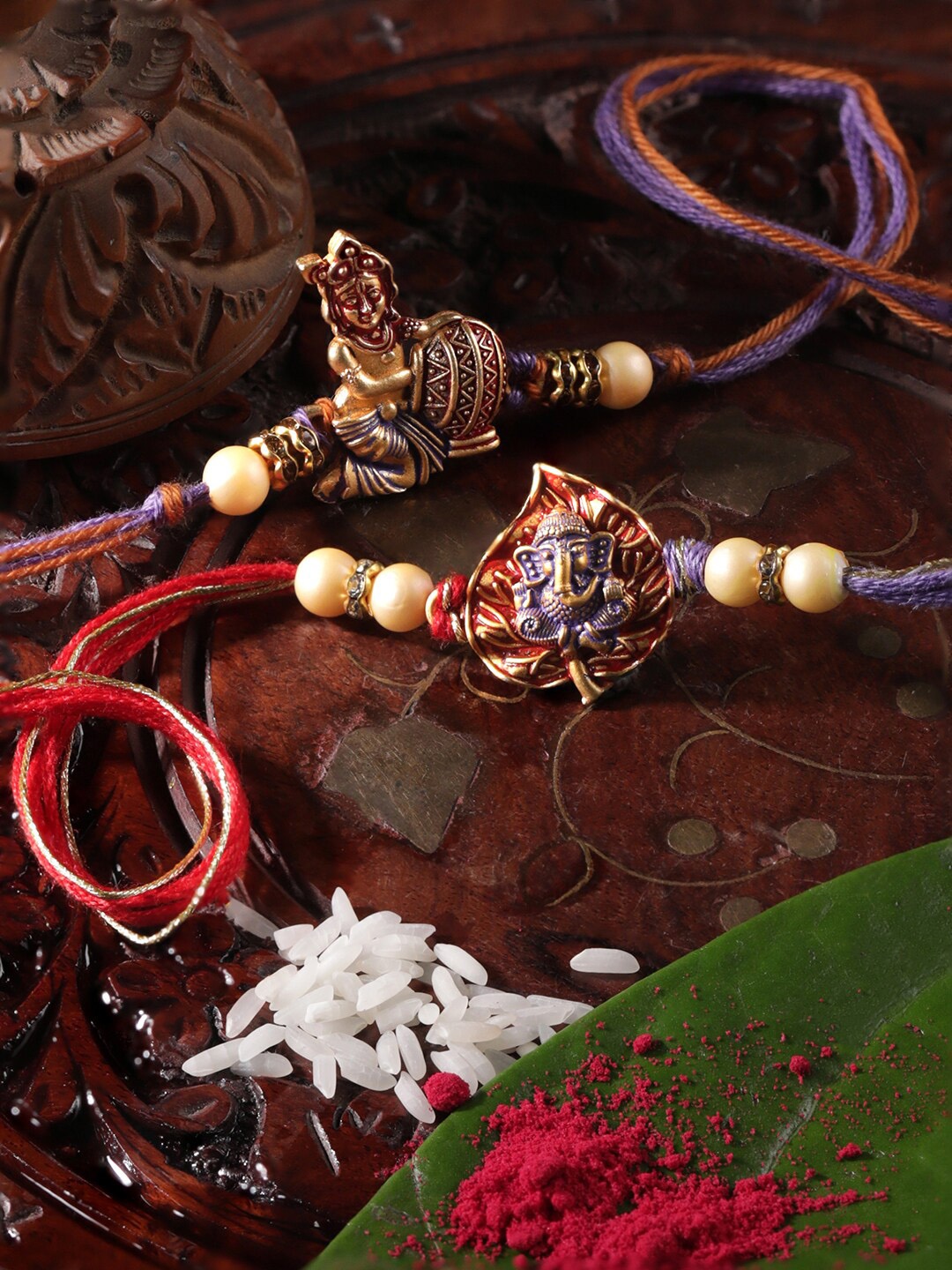 

Rubans Set Of 2 Beaded & Krishna & Ganesha Charm Rakhi With Roli & Rice, Red