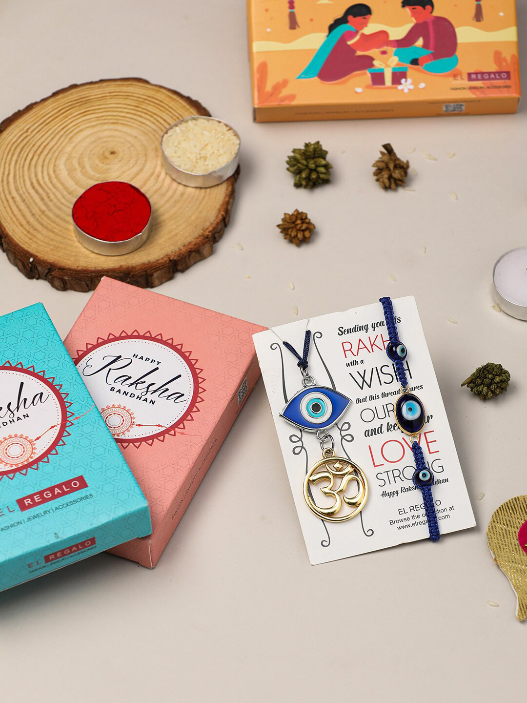 

EL REGALO Bhaiya Bhabhi Set Of 2 Om Evil Eye Charm Rakhi With Roli Chawal Card Gift Set, Blue