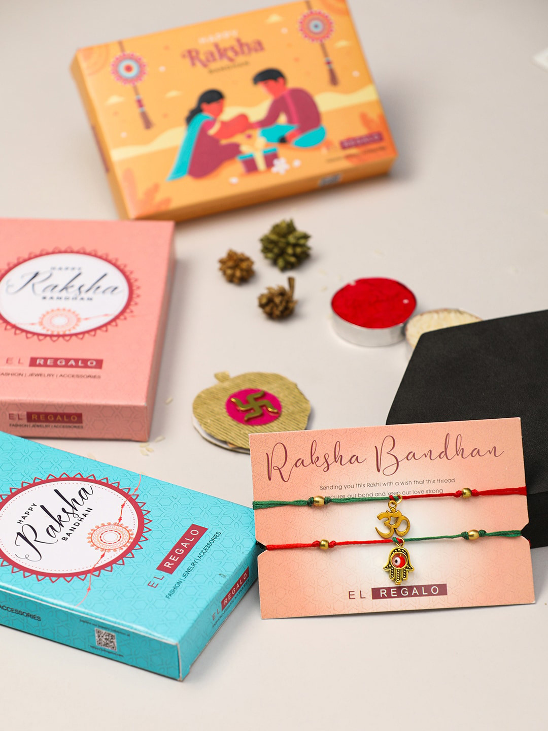 

EL REGALO Bhaiya Bhabhi Set Of 2 Om Hamsa Thread Rakhi With Roli Chawal and Card, Red
