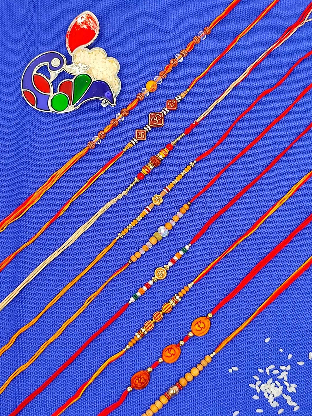 

CRAYTON Men Set Of 9 Rakhi With Roli Chaval Holder, Red