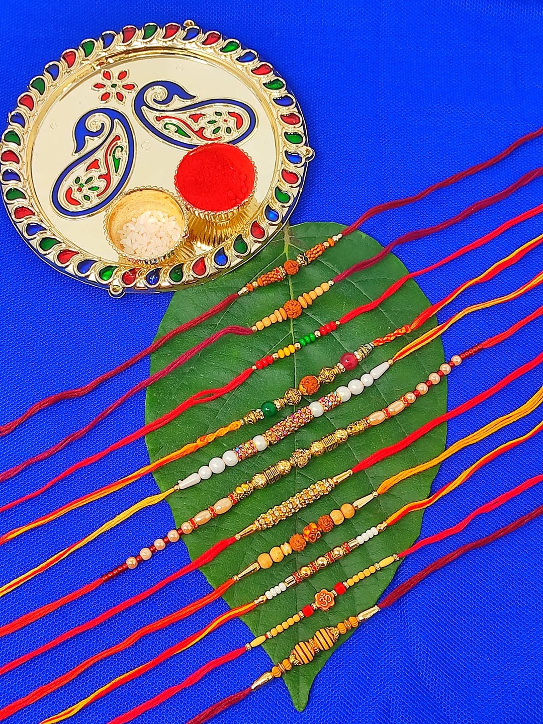 

CRAYTON Set of 11 Rakhi With Roli Chaval Holder & Small Plate, Red