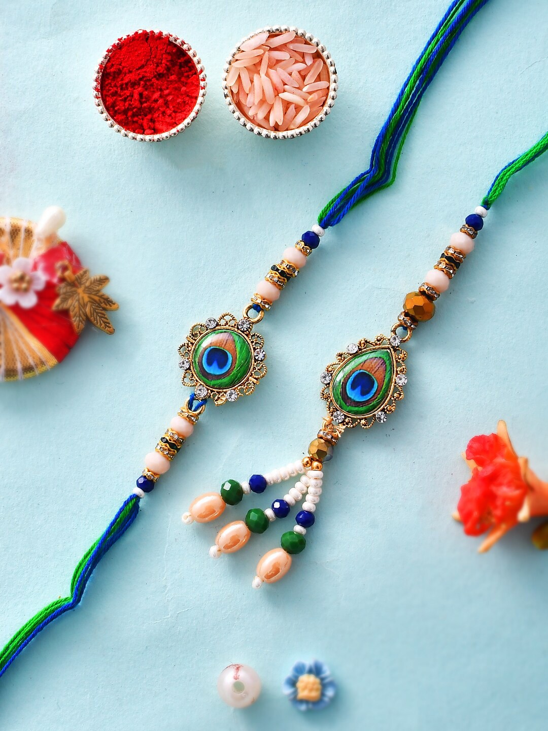 

Aapno Rajasthan Unisex Set Of 2 Beads Woven Mor Pankh Resin Bhaiya Bhabhi Rakhi Set, Blue