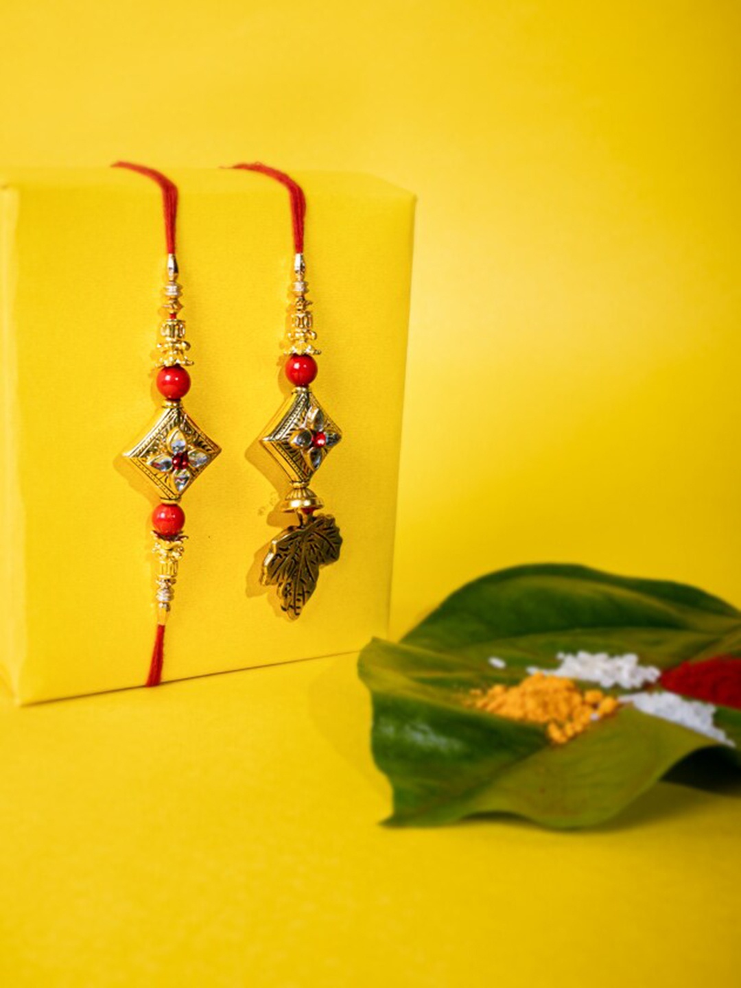 

PANASH Set Of 2 Gold-Plated Kundan Embellished Bhaiya Bhabhi Rakhis with Roli Chawal, Red