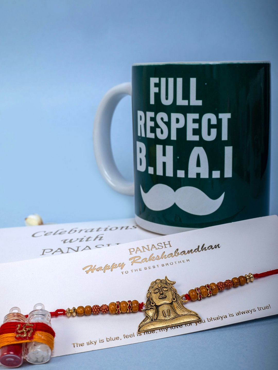 

PANASH Set Of 3 Gold-Plated Shiv Adiyogi Rakhi With Mug & Roli Chawal