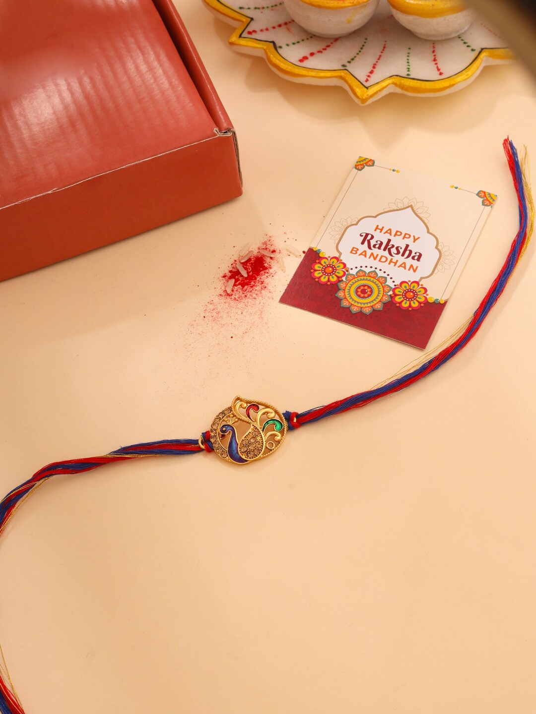 

Natures Buggy Gold Plated Peacock Charm Rakhi