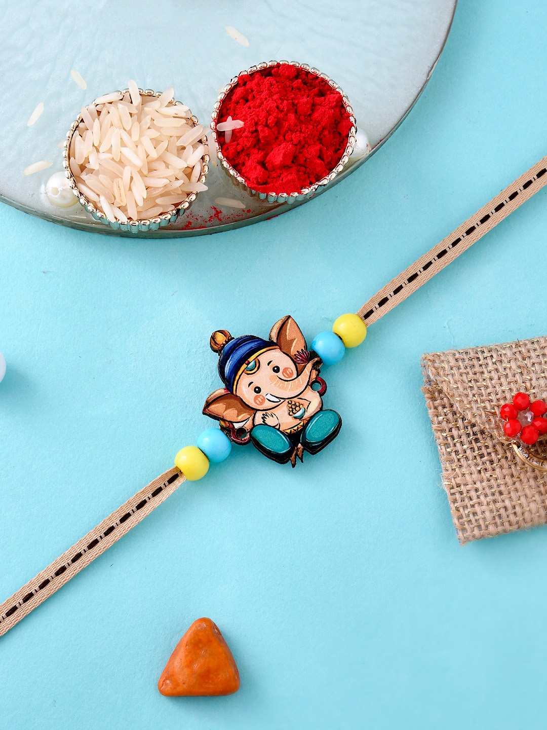 

Aapno Rajasthan Kids Ganesha Designed Thread Rakhi With Roli Chawal & Greeting Card, Blue