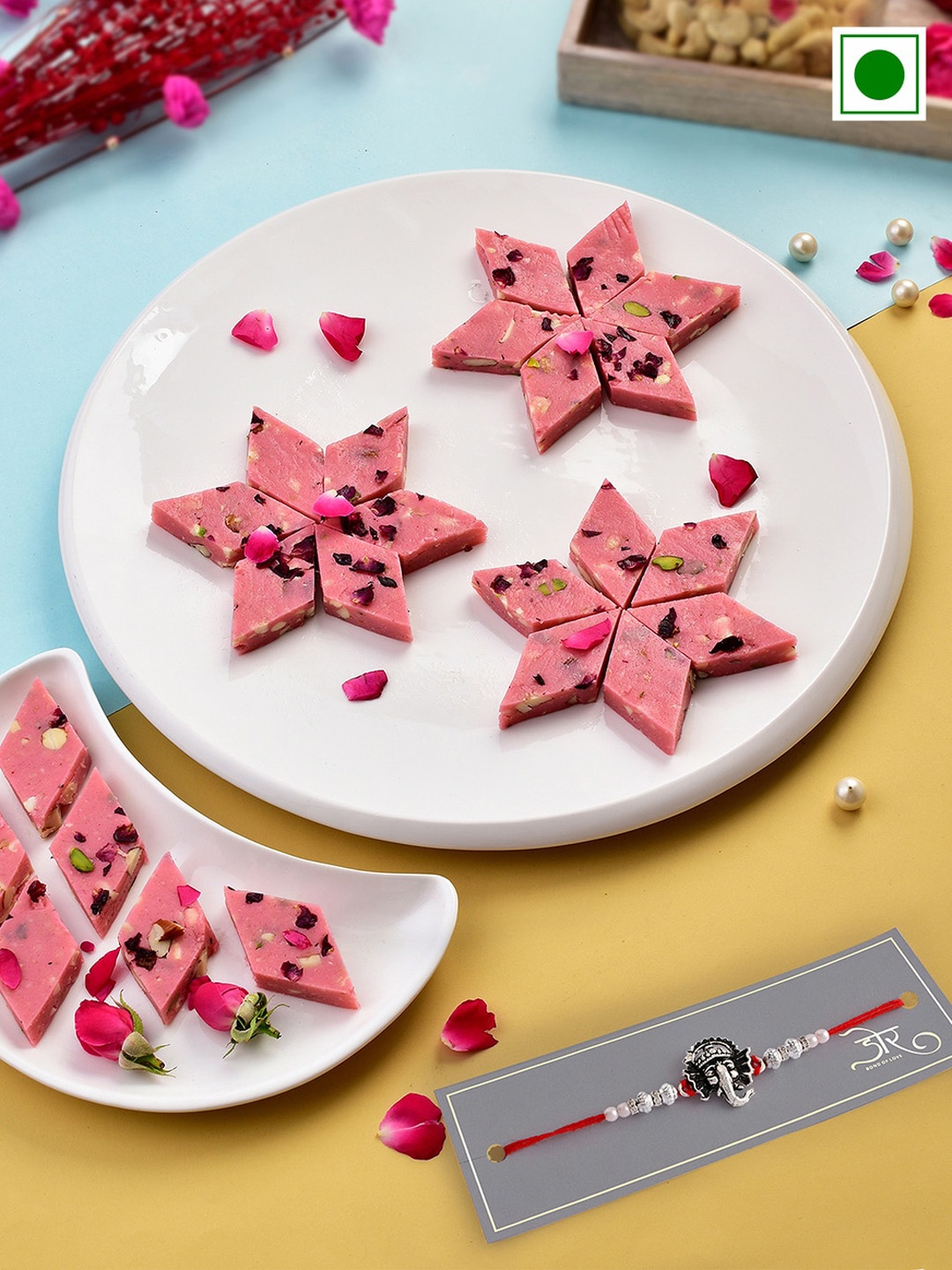 

RawFruit Ganesh Charm Rakhi With Roli Chawal & Rose Katli Sweets-200 gms, Red