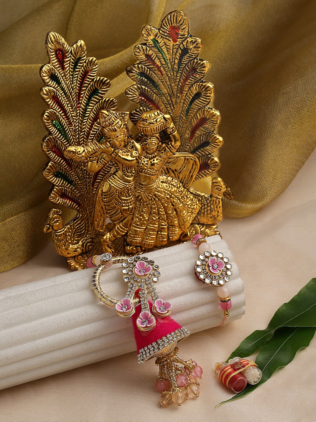 

PANASH Unisex Gold-Plated Rakhi With Radha Krishna Idol & Roli Chawal