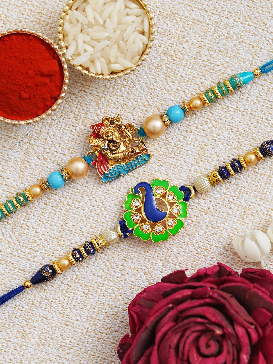 

Fashion Bizz Set of 2 Peacock & Ganesha Charm Rakhis Comes With Roli & Chawal, Blue
